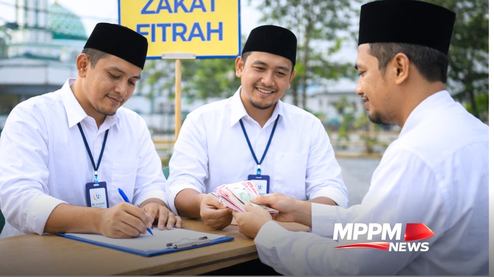 Petugas zakat fitrah mencatat pembayaran zakat dari masyarakat di meja pelayanan zakat dengan pakaian santri peci hitam dan baju putih