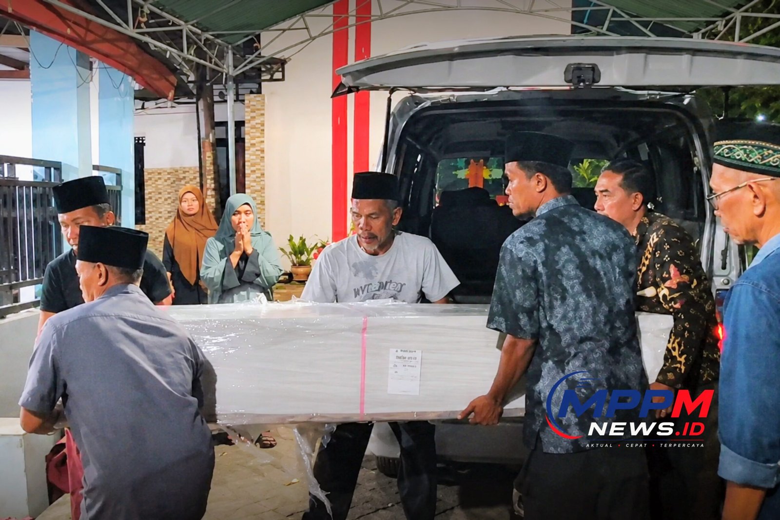 Petugas dan keluarga menurunkan jenazah PMI asal Bangkalan yang dipulangkan MPPM dari Malaysia setibanya di rumah duka di Desa Pakong, Kecamatan Modung, Kabupaten Bangkalan, Jawa Timur.