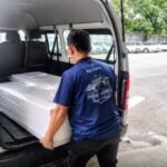 Petugas TPPJ MPPM memasukkan jenazah PMI yang dipulangkan dari Malaysia ke dalam kendaraan untuk proses pengantaran.